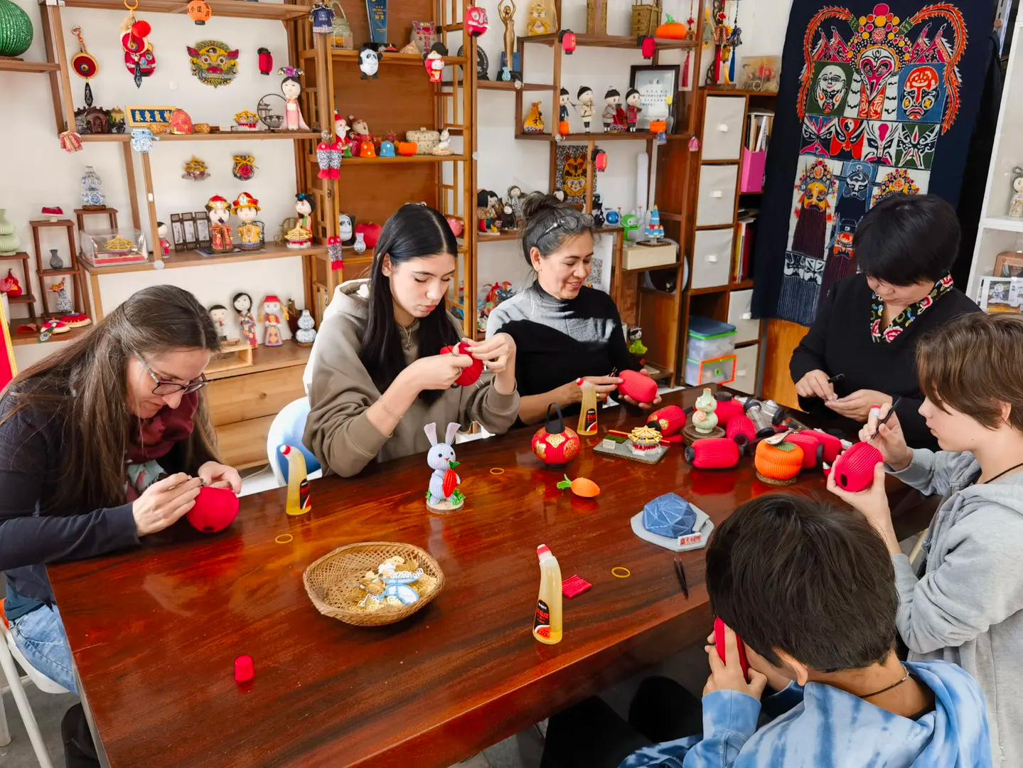 Travelers making traditional lantern crafts with a local host