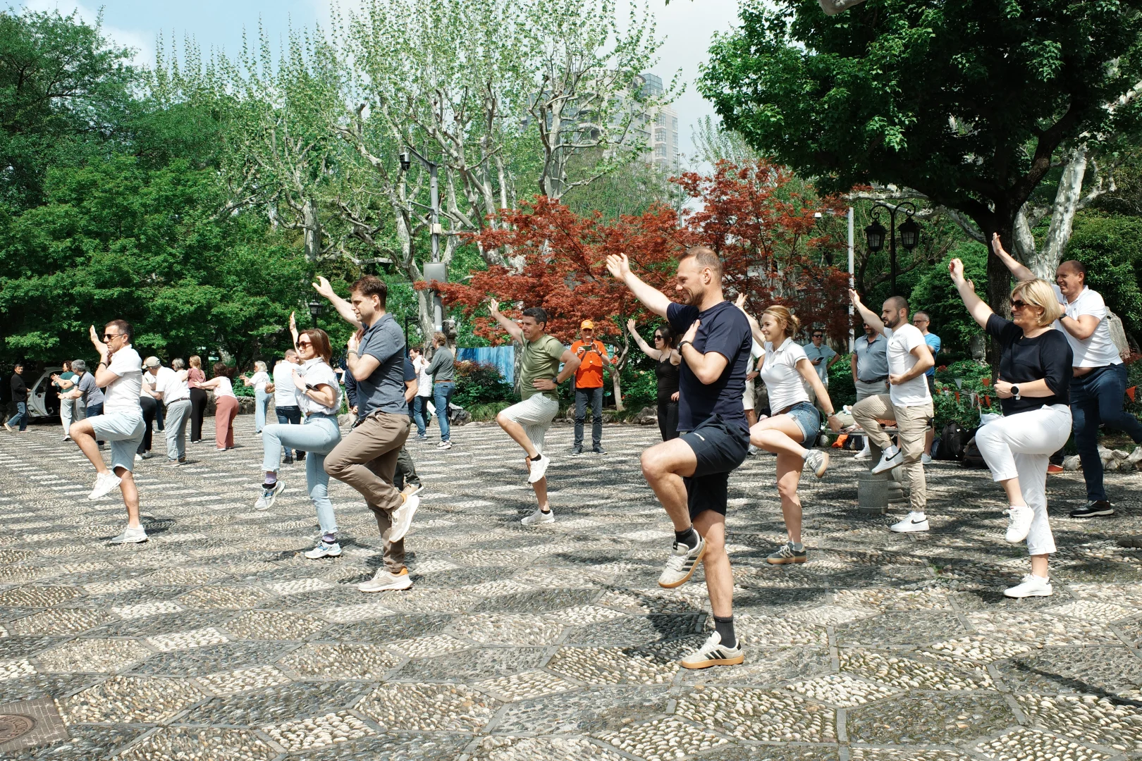 Travelers practicing tai chi together in a city park
