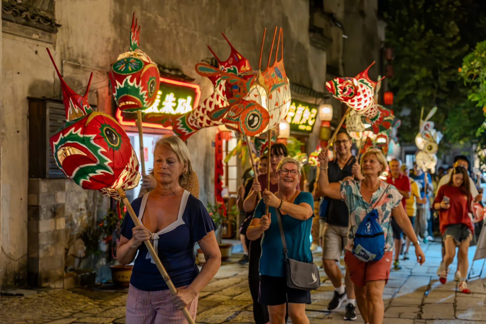 Travelers carrying traditional lanterns during an evening cultural experience